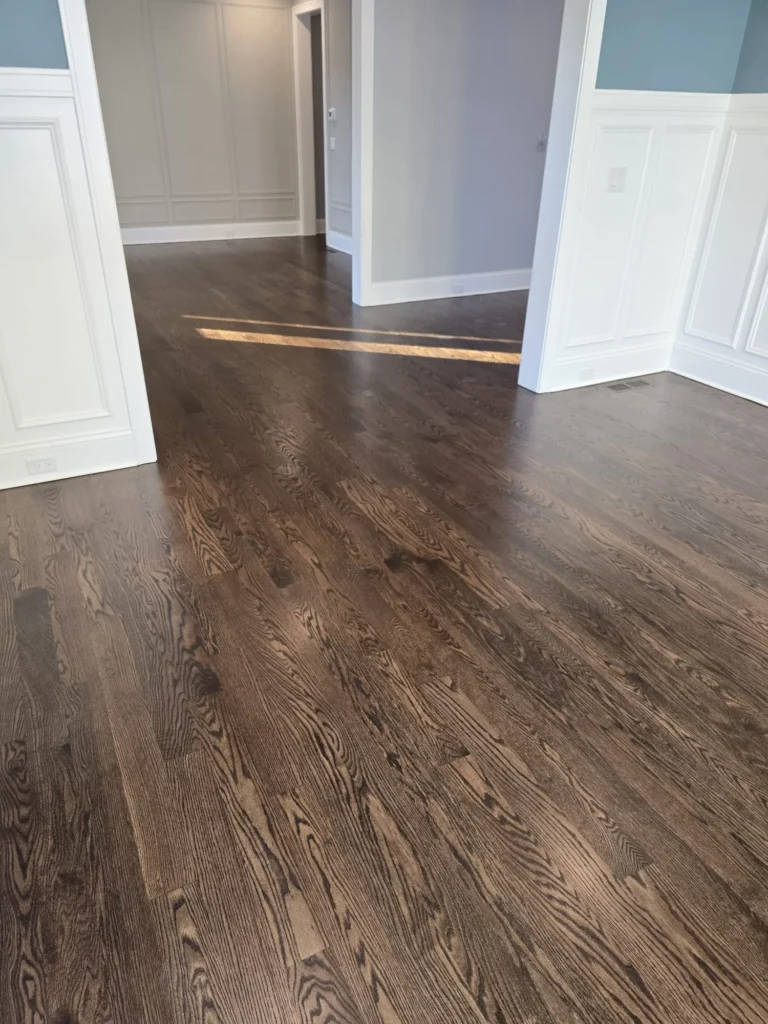 Dark stained hardwood flooring in dining area refinished by RZR Hardwood Flooring