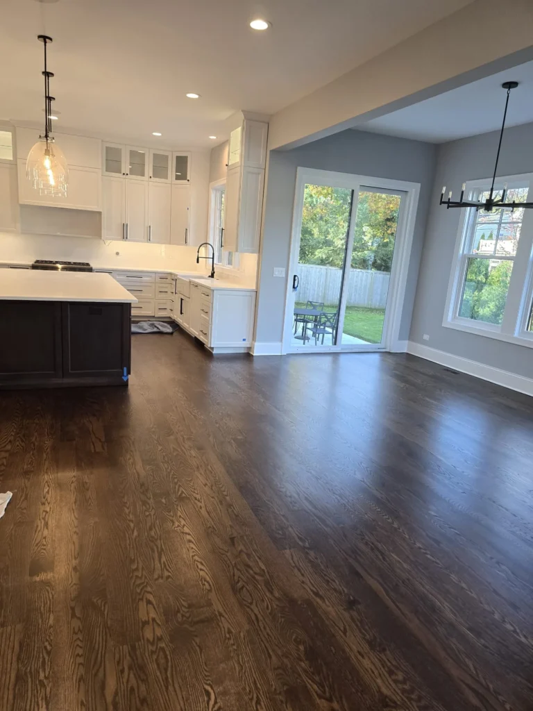 Dark hardwood floor refinishing in open kitchen and living area in Chicagoland