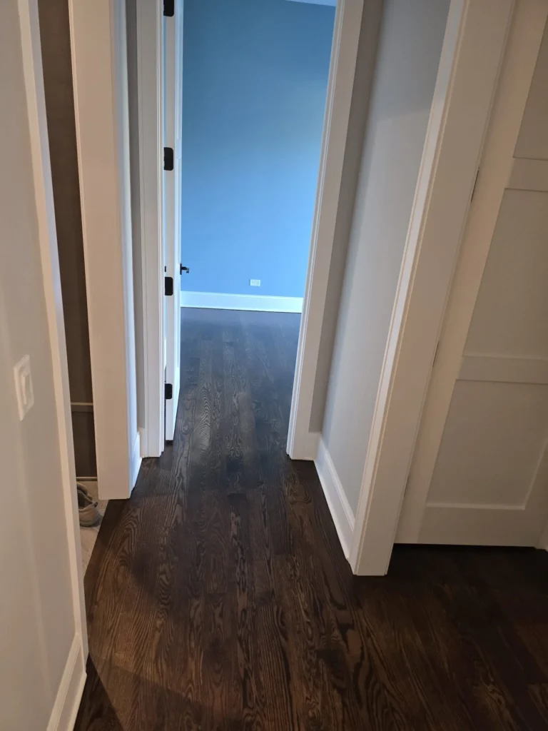 Refinished hardwood flooring extending through second-floor hallway