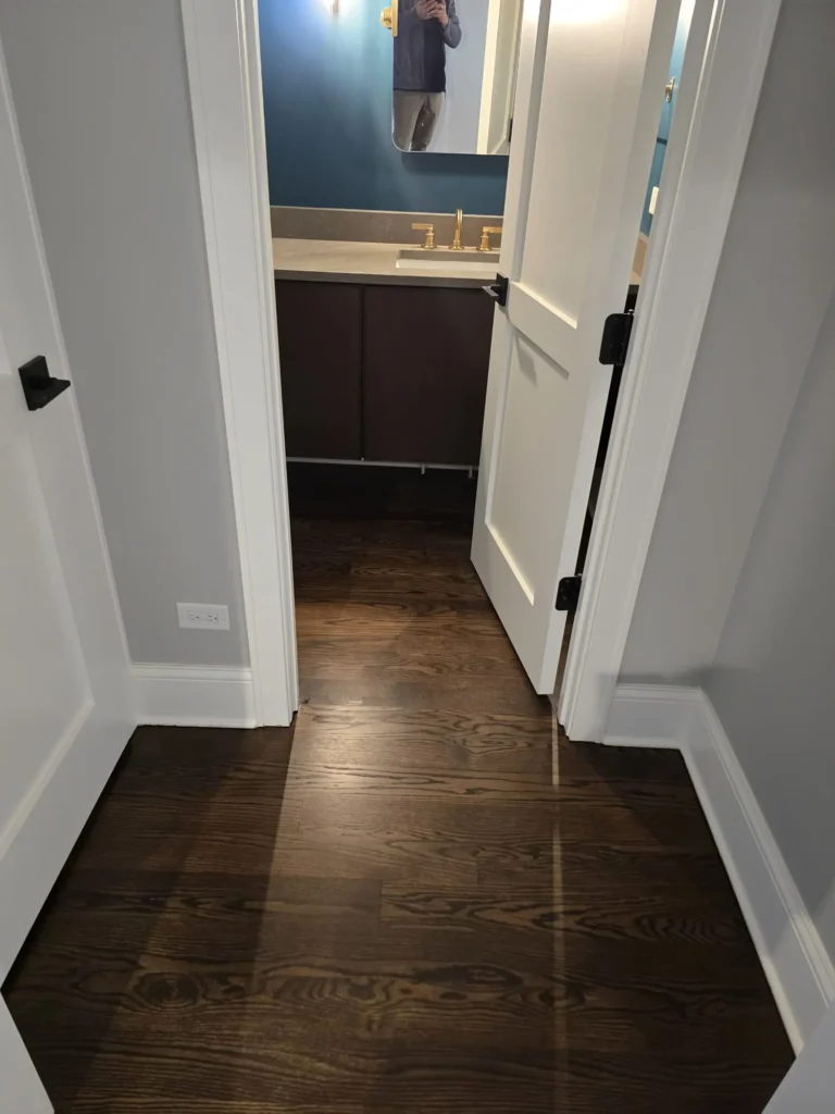 Dark hardwood floor refinishing in hallway and powder room