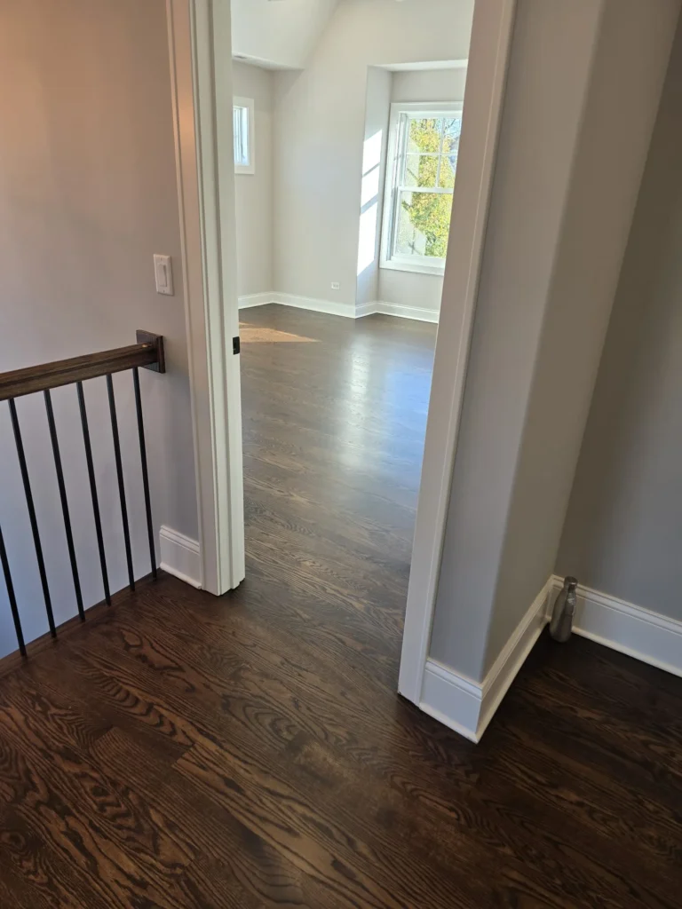 Refinished hardwood flooring connecting upstairs hallway and bedroom