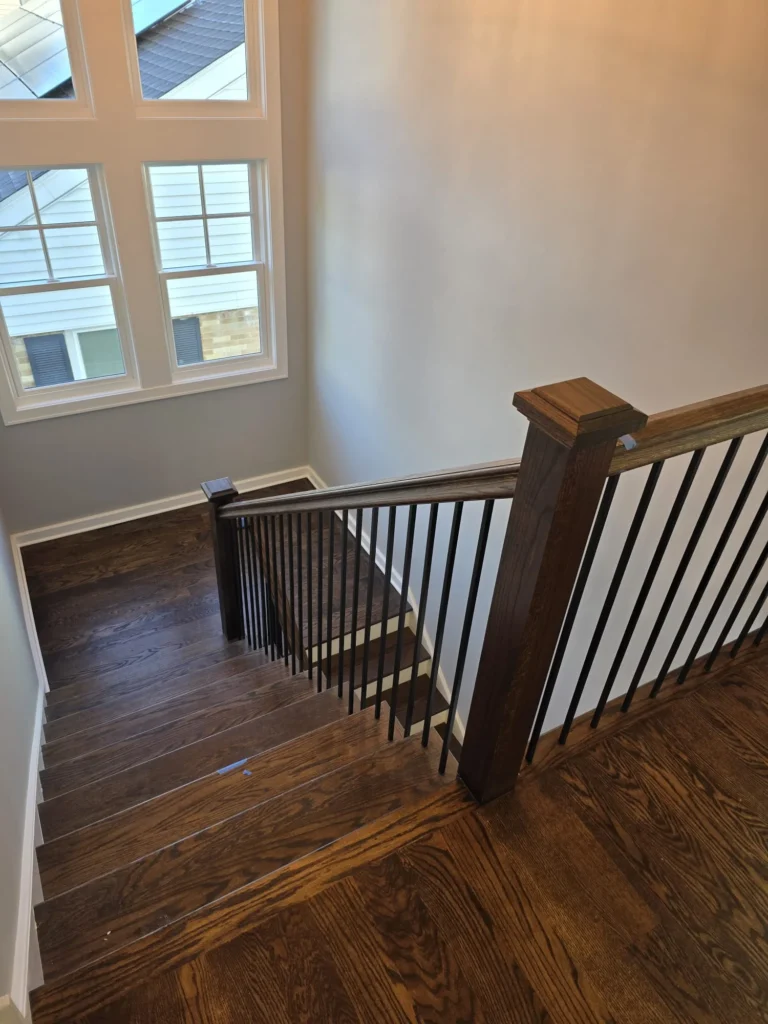 Refinished hardwood staircase and railing with matching dark wood finish
