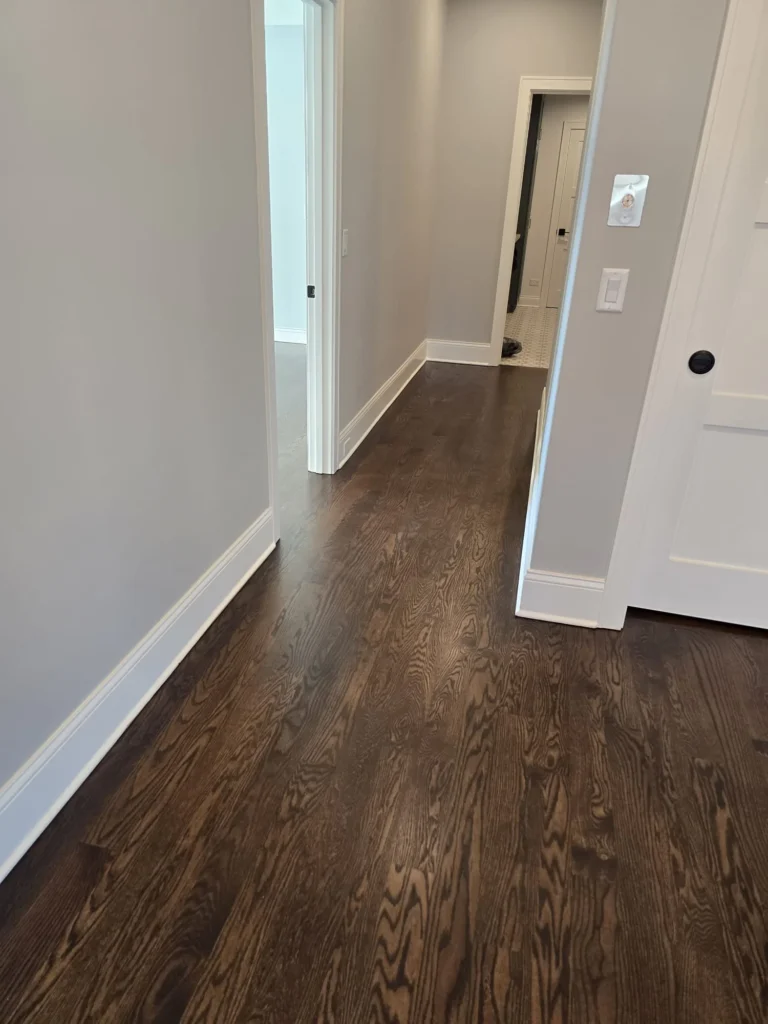 Dark hardwood flooring refinished throughout second-floor hallway